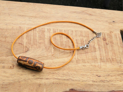 9 Eyes Dzi Bead made of brown grained relief Agate necklace.  It's believed to offer protection, promote spiritual growth, and bring harmony
