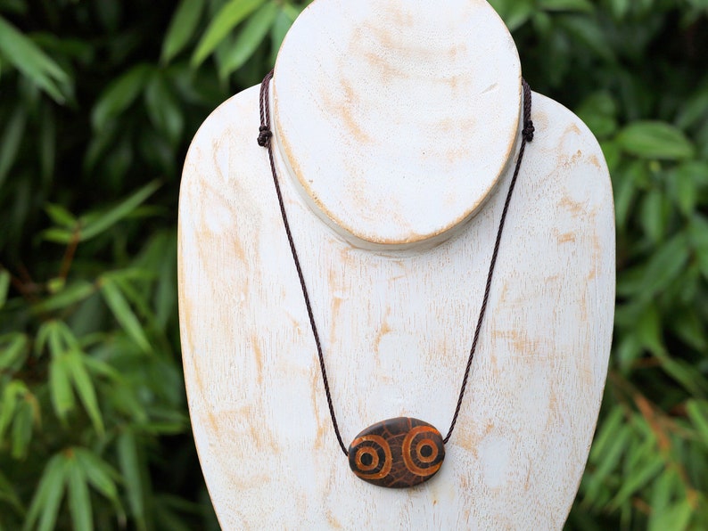 Brown Oval Flat 4 eyed Dzi Bead, Big Flat Barrel Vintage Tibetan Agate.  Overall, the four-eyed dzi bead is highly valued for its powerful protective energy and its ability to promote harmony,