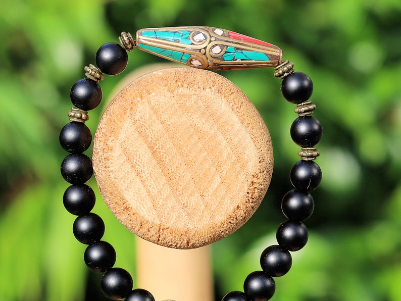 The Shaligram stones with Nepalese Brass beads from Nepal. Inlaid with turquoise and coral. Size : 25 x 10 mm