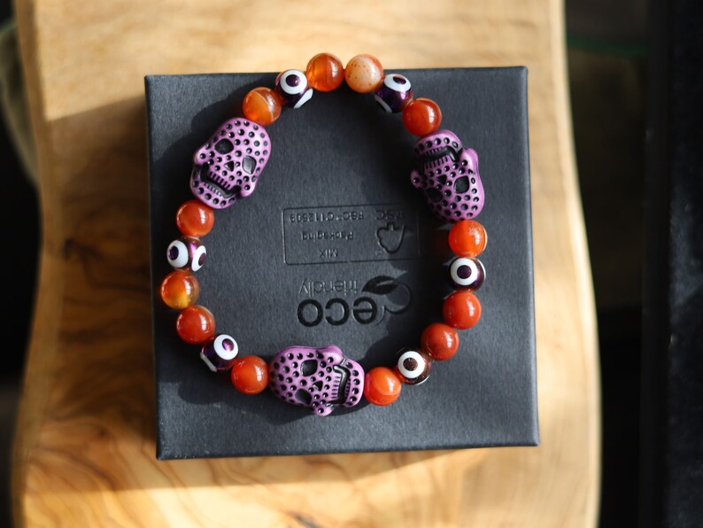 Crazy Lace Agate, EVIL EYE with Detailed, large resin bead: Skull. They can symbolize the acceptance of death as a natural part of life.