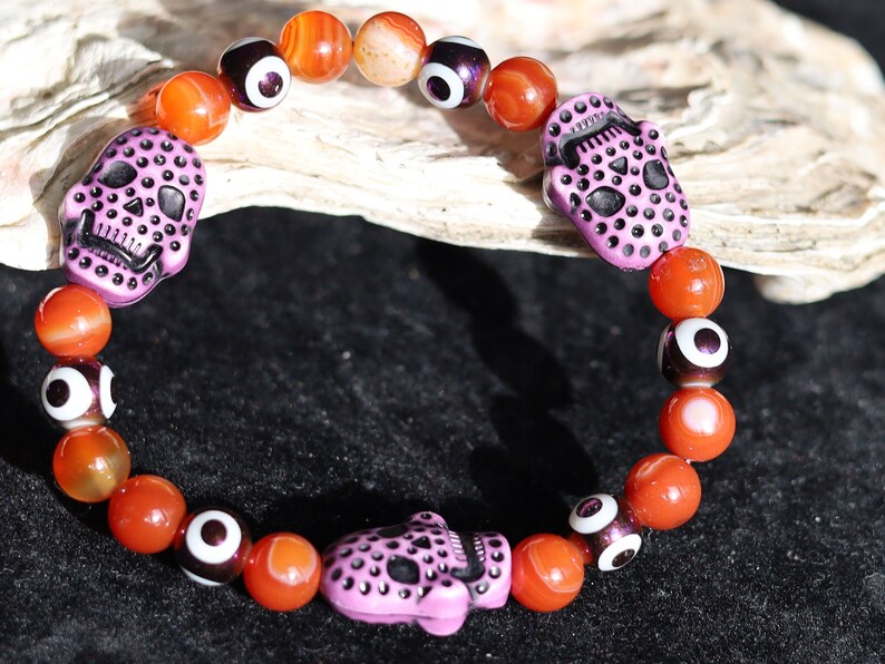 Crazy Lace Agate, EVIL EYE with Detailed, large resin bead: Skull. They can symbolize the acceptance of death as a natural part of life.