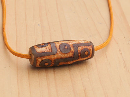 9 Eyes Dzi Bead made of brown grained relief Agate necklace.  It's believed to offer protection, promote spiritual growth, and bring harmony