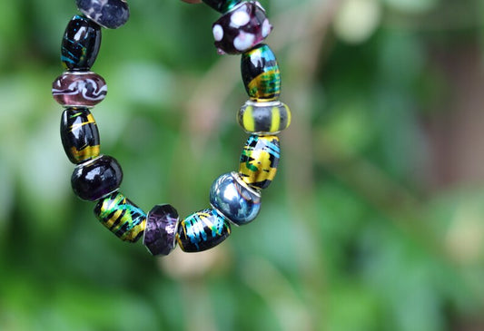 Glass beads with an impressive finish. Cosmic Oval Black w Gold 10x14mm. Combined with Glassbead aqua-red with white and yellow