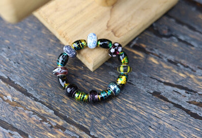 Glass beads with an impressive finish. Cosmic Oval Black w Gold 10x14mm. Combined with Glassbead aqua-red with white and yellow