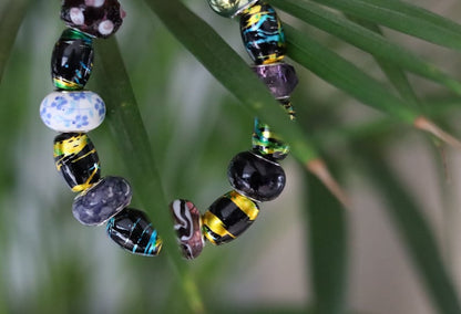 Glass beads with an impressive finish. Cosmic Oval Black w Gold 10x14mm. Combined with Glassbead aqua-red with white and yellow