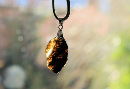 Our Indochinite Black Tektite Thailand Pendant is here to elevate your spiritual journey to new heights