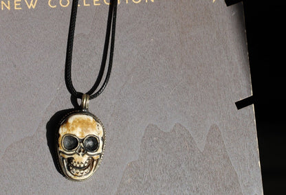 A bone skull amulet or pendant with metal mounting that originates from Nepal can hold various meanings and cultural significance.