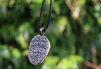A bone skull amulet or pendant with metal mounting that originates from Nepal can hold various meanings and cultural significance.