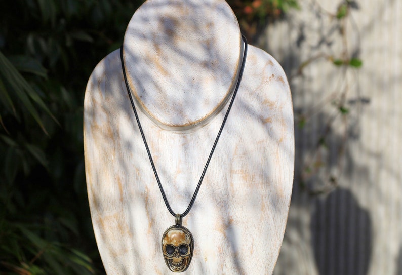 A bone skull amulet or pendant with metal mounting that originates from Nepal can hold various meanings and cultural significance.