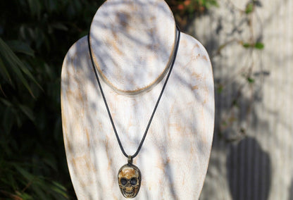 A bone skull amulet or pendant with metal mounting that originates from Nepal can hold various meanings and cultural significance.