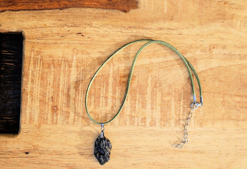 Our Indochinite Black Tektite Thailand Pendant is here to elevate your spiritual journey to new heights