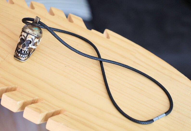 A bone skull amulet or pendant with metal mounting that originates from Nepal can hold various meanings and cultural significance.