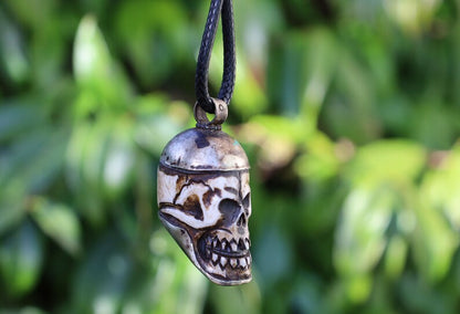 A bone skull amulet or pendant with metal mounting that originates from Nepal can hold various meanings and cultural significance.