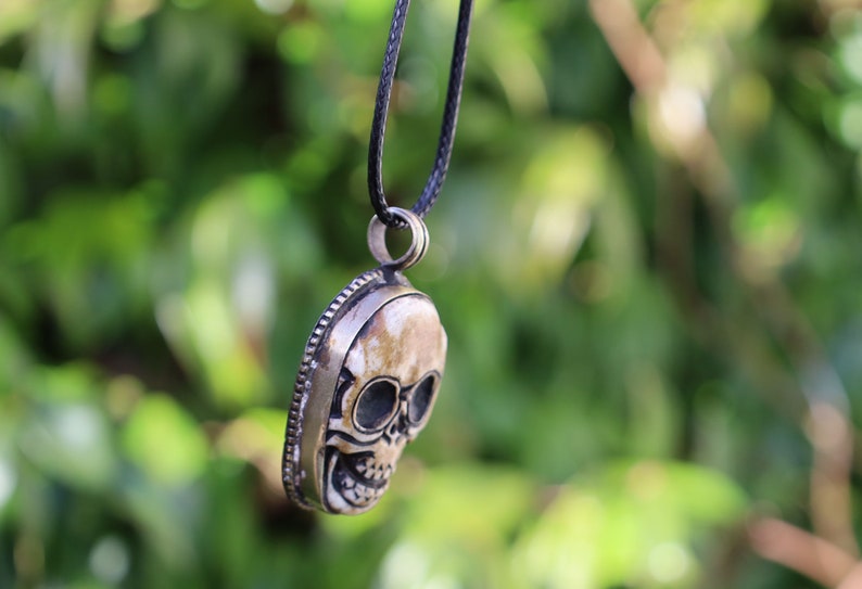 A bone skull amulet or pendant with metal mounting that originates from Nepal can hold various meanings and cultural significance.