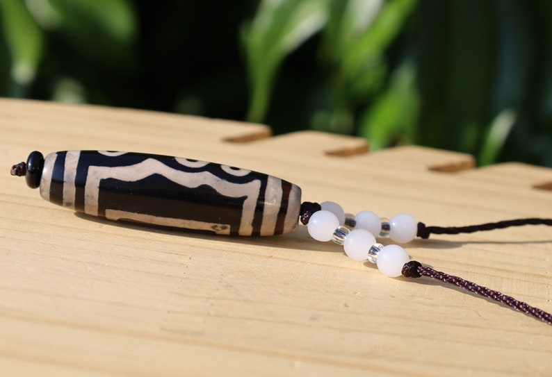 Double Tiger Tooth, or Tasso pendant necklace.  It is also revered as a spiritual object, capable of keeping away evil things