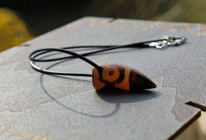 Three-eye Crescent Dzi Beads pendant necklace. In Buddhism the bead symbolizes the god of wealth Yellow Dzambala (Kubera)