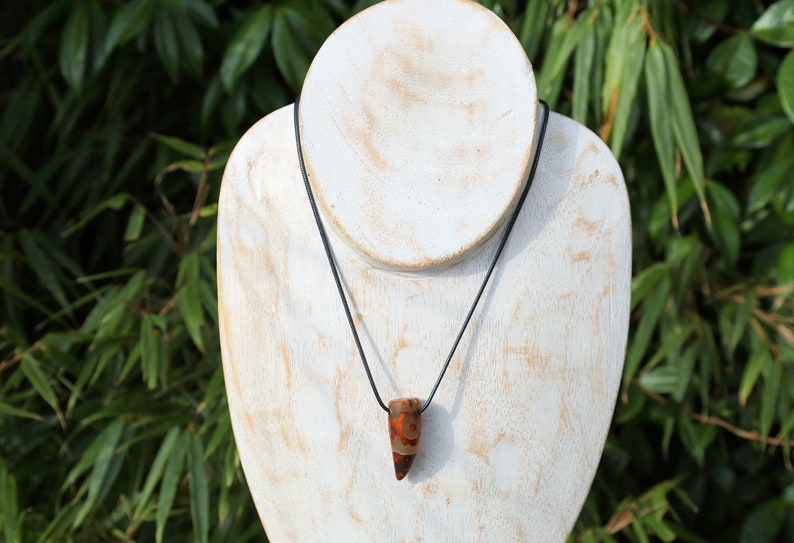 Three-eye Crescent Dzi Beads pendant necklace. In Buddhism the bead symbolizes the god of wealth Yellow Dzambala (Kubera)