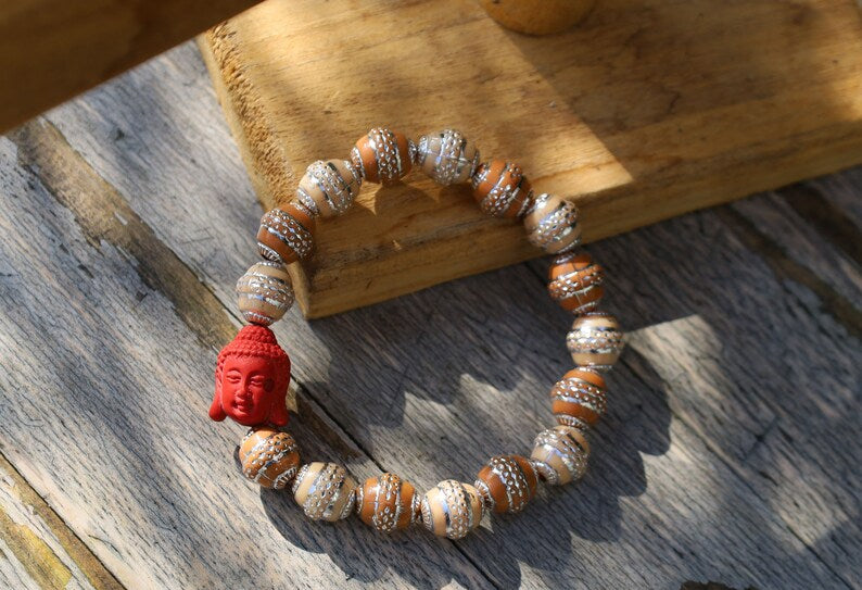 Beautiful large, handcrafted bead of real red Cinnabar Buddha. With repoussé beads brown and creme.