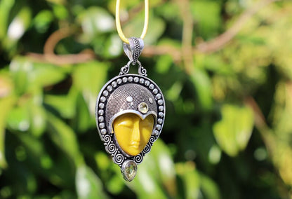 Carved Face Citrine 925, silver plated pendant. Bali Godess. Citrine, known for its captivating yellow to golden hues, embodies the warmth and energy of the sun.