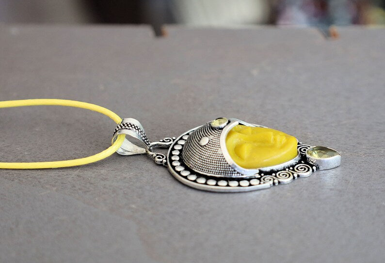 Carved Face Citrine 925, silver plated pendant. Bali Godess. Citrine, known for its captivating yellow to golden hues, embodies the warmth and energy of the sun.