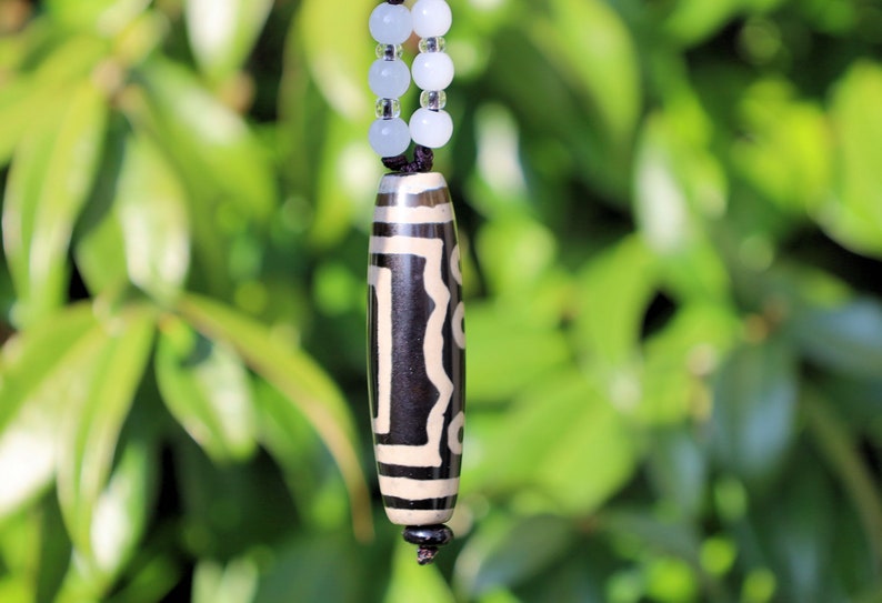 Double Tiger Tooth, or Tasso pendant necklace.  It is also revered as a spiritual object, capable of keeping away evil things