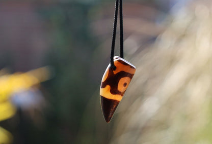 Three-eye Crescent Dzi Beads pendant necklace. In Buddhism the bead symbolizes the god of wealth Yellow Dzambala (Kubera)