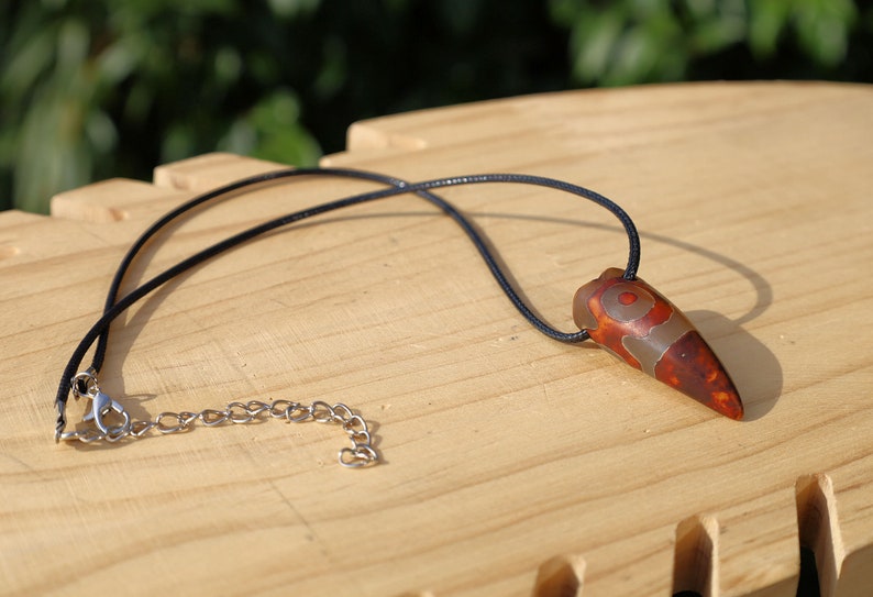Three-eye Crescent Dzi Beads pendant necklace. In Buddhism the bead symbolizes the god of wealth Yellow Dzambala (Kubera)