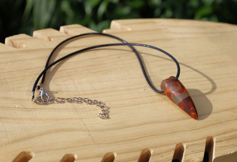 Three-eye Crescent Dzi Beads pendant necklace. In Buddhism the bead symbolizes the god of wealth Yellow Dzambala (Kubera)
