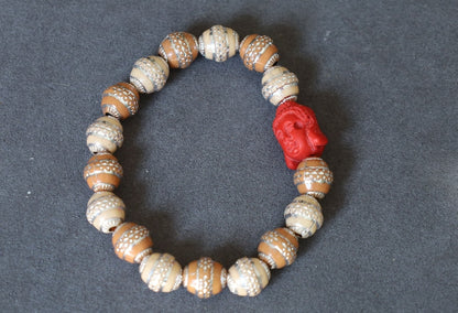 Beautiful large, handcrafted bead of real red Cinnabar Buddha. With repoussé beads brown and creme.