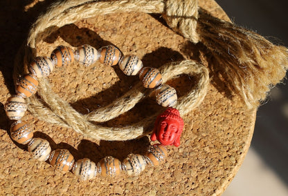 Beautiful large, handcrafted bead of real red Cinnabar Buddha. With repoussé beads brown and creme.