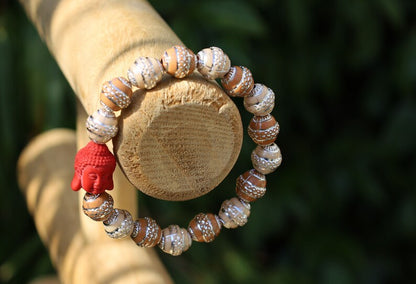 Beautiful large, handcrafted bead of real red Cinnabar Buddha. With repoussé beads brown and creme.
