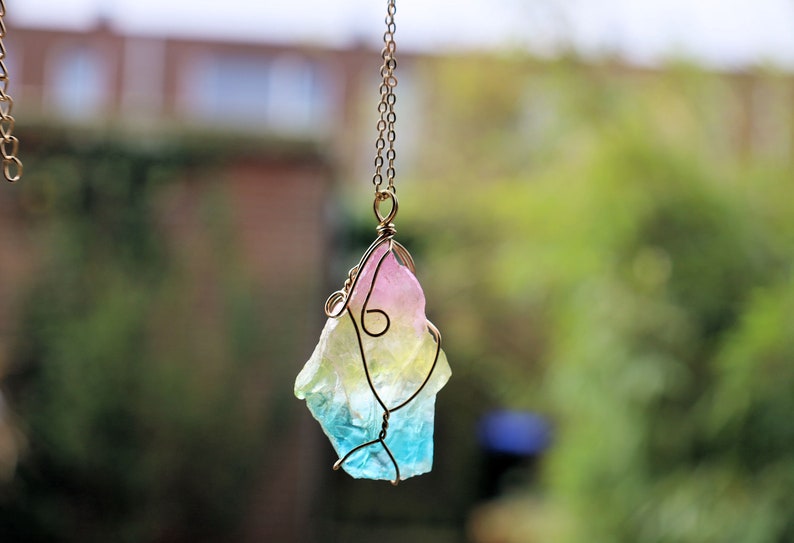 Colorful Quartz Crystal Rainbow Stone Wire Wrapped Crystal Pendant  A Quartz Crystal Rainbow Stone pendant encompasses the natural beauty and energetic properties of quartz crystal