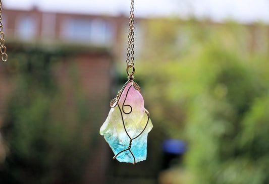 Colorful Quartz Crystal Rainbow Stone Wire Wrapped Crystal Pendant  A Quartz Crystal Rainbow Stone pendant encompasses the natural beauty and energetic properties of quartz crystal