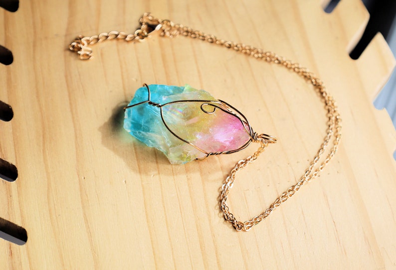 Colorful Quartz Crystal Rainbow Stone Wire Wrapped Crystal Pendant  A Quartz Crystal Rainbow Stone pendant encompasses the natural beauty and energetic properties of quartz crystal