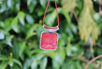 A red evil eye pendant carries with it the ancient belief in the protective power of the "evil eye," a symbol meant to ward off harm and malevolent energies directed towards the wearer.