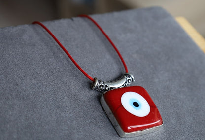 A red evil eye pendant carries with it the ancient belief in the protective power of the "evil eye," a symbol meant to ward off harm and malevolent energies directed towards the wearer.