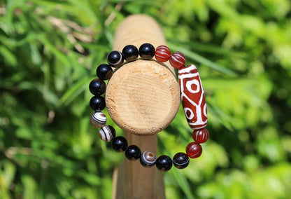 The six-eye dZi bead symbolizes luck and control, promoting health and longevity. With black striped agate 10 mm beads.  physical strength.