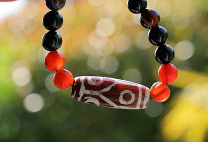 The six-eye dZi bead symbolizes luck and control, promoting health and longevity. With black striped agate 10 mm beads.  physical strength.