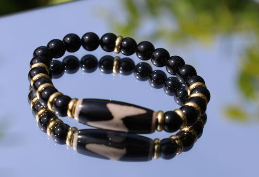 Five eyed lightning Dzi  bead with black onyx beads bracelet and Brass Spacer Beads, Rings, Golden color. Surrounded by myth and mystery