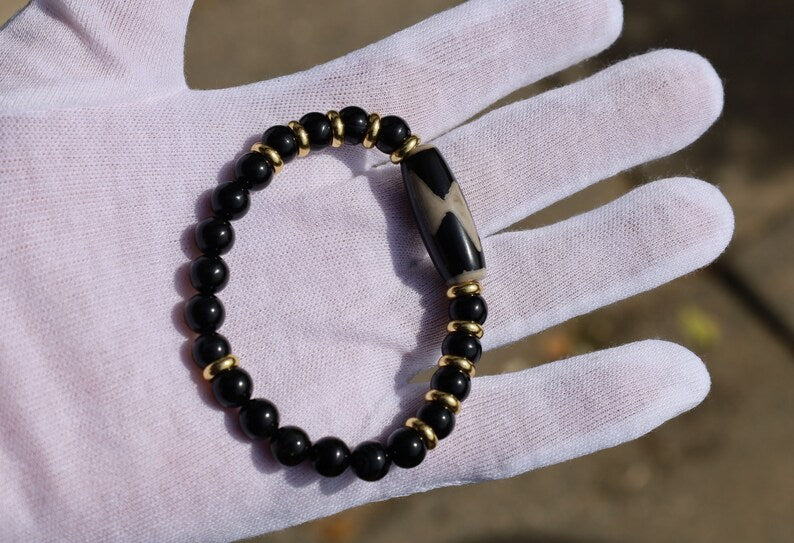 Five eyed lightning Dzi  bead with black onyx beads bracelet and Brass Spacer Beads, Rings, Golden color. Surrounded by myth and mystery
