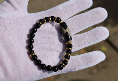 Five eyed lightning Dzi  bead with black onyx beads bracelet and Brass Spacer Beads, Rings, Golden color. Surrounded by myth and mystery