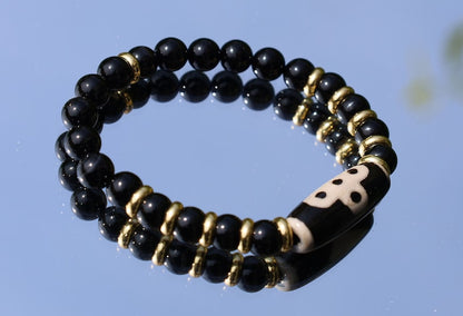 Five eyed lightning Dzi  bead with black onyx beads bracelet and Brass Spacer Beads, Rings, Golden color. Surrounded by myth and mystery