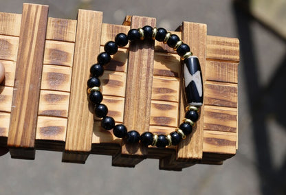 Five eyed lightning Dzi  bead with black onyx beads bracelet and Brass Spacer Beads, Rings, Golden color. Surrounded by myth and mystery
