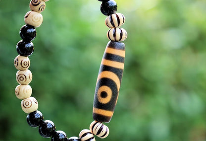 Old Two-eye dZi bead Bracelet with  Onyx and Spiral pattern beads. Visually striking with profound spiritual significance.