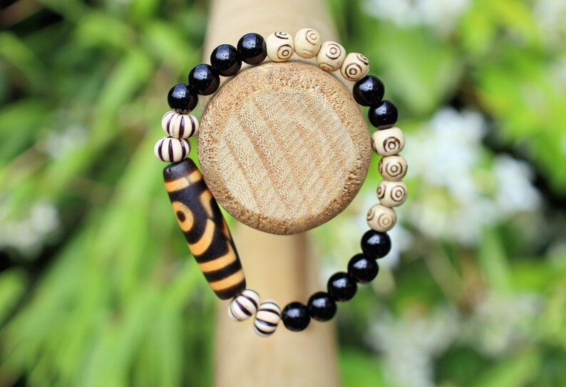 Old Two-eye dZi bead Bracelet with  Onyx and Spiral pattern beads. Visually striking with profound spiritual significance.