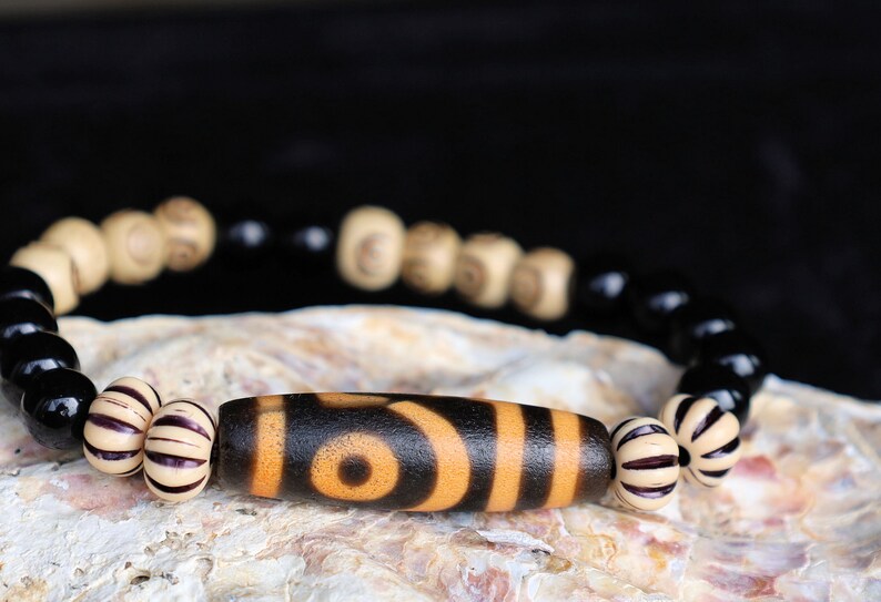 Old Two-eye dZi bead Bracelet with  Onyx and Spiral pattern beads. Visually striking with profound spiritual significance.