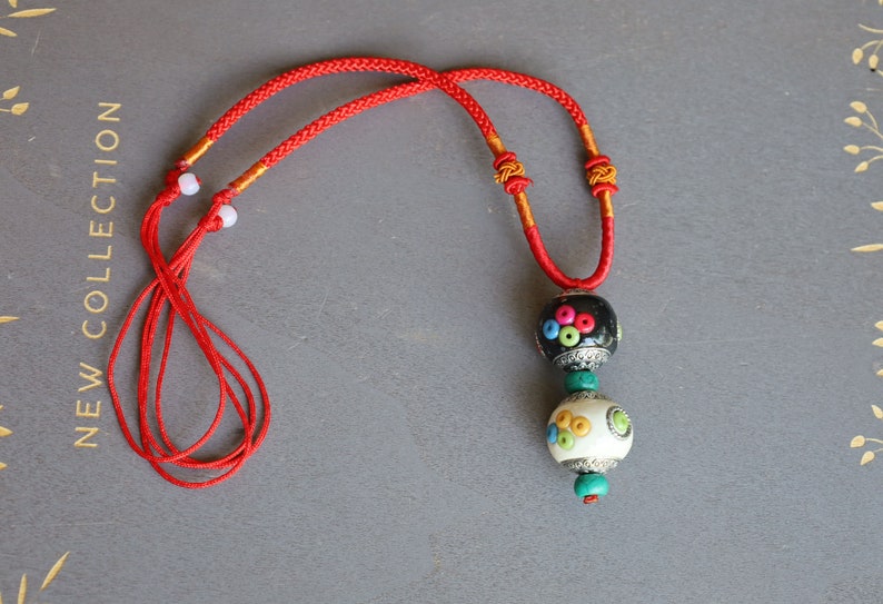 Introducing our exquisite Double Handmade Tibetan Style Round Beads Necklace, featuring a unique blend of craftsmanship and tradition