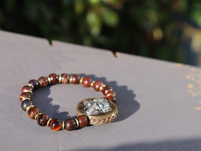 Red Tiger Eye and Beautiful 3D silvertone metal Ganesh decoration on both front as back.