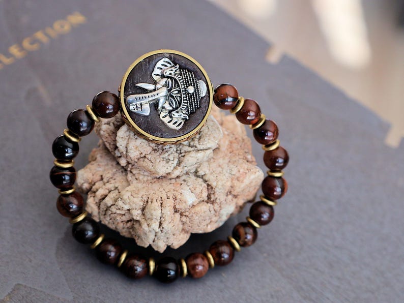 Red Tiger Eye and Beautiful 3D silvertone metal Ganesh decoration on both front as back.