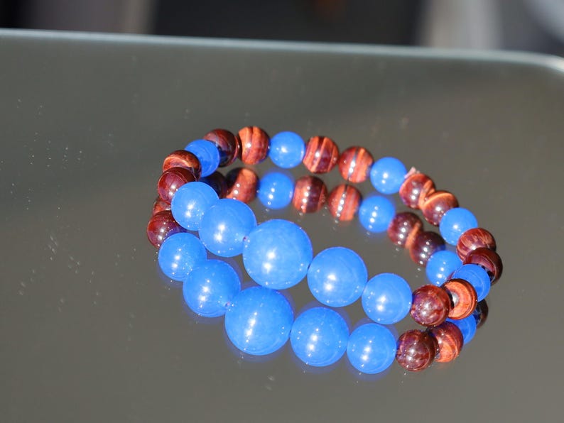 A bracelet made with Royal Blue Jade and Red Tiger Eye beads is a striking combination that blends elegance and vibrant energy.